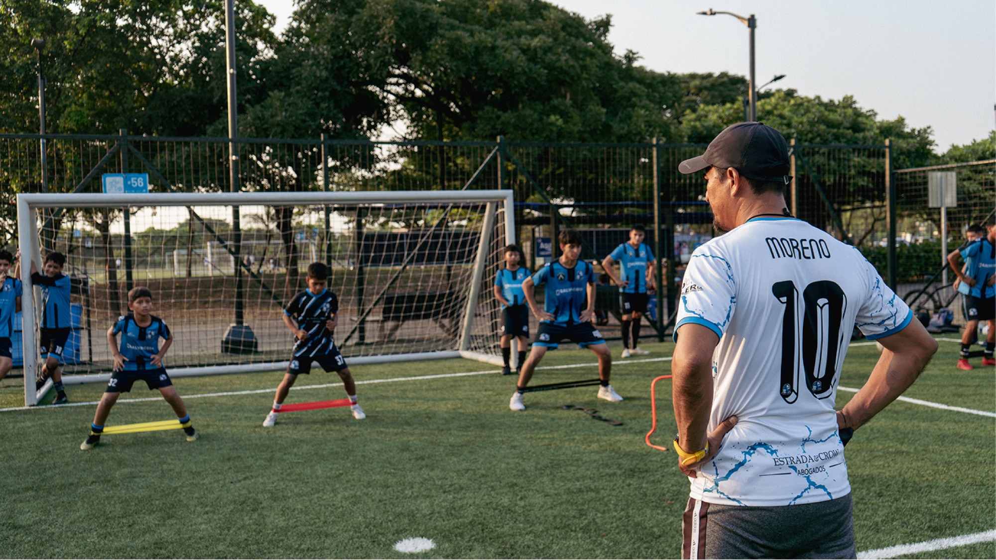 Entrenador observando a sus jugadores durante un ejercicio